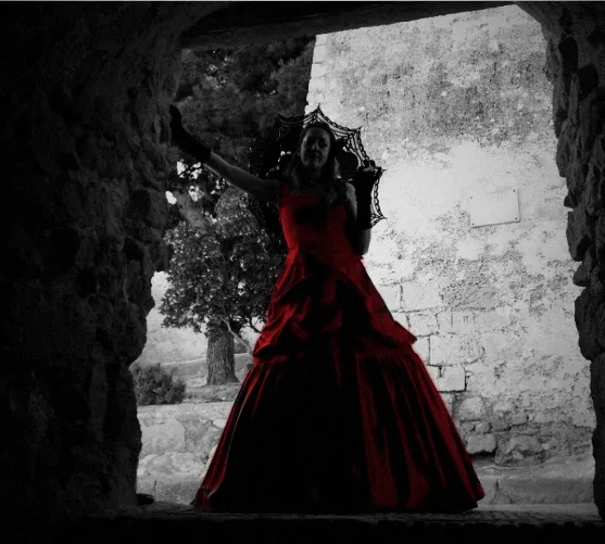 Mari Carmen Pacheco Picazo con vestido rojo bajo un arco de piedra